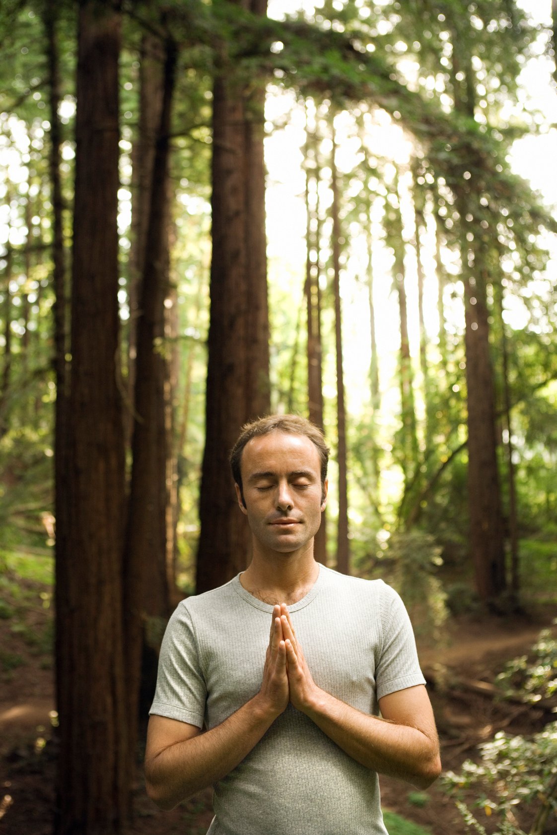 Man meditating in forest